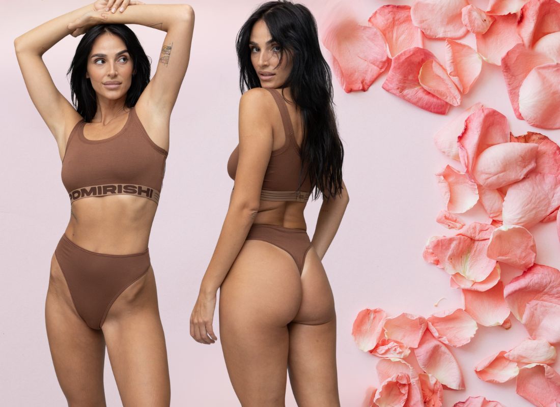 roze pozadina sa laticama ruza i devojka u pomirishi donjem vešu, čarapama i topu