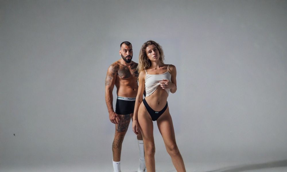 momak i devojka poziraju u donjem vešu na sivoj pozadini