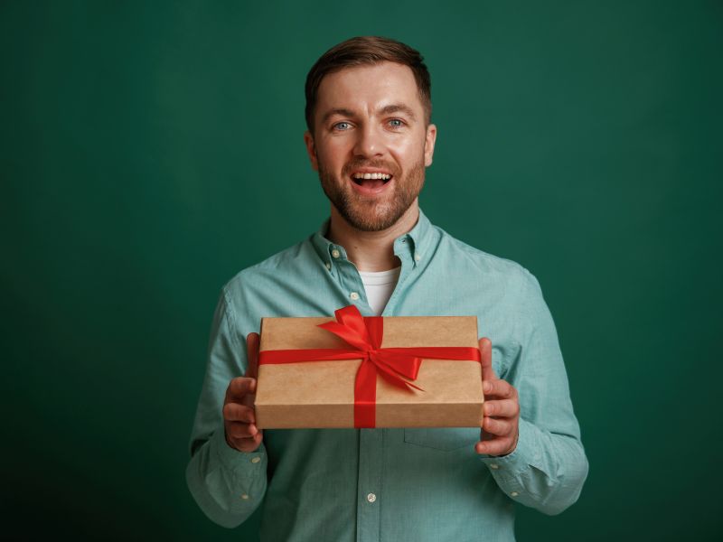 prikaz momka koji drži poklon u ruci, zelena pozadina